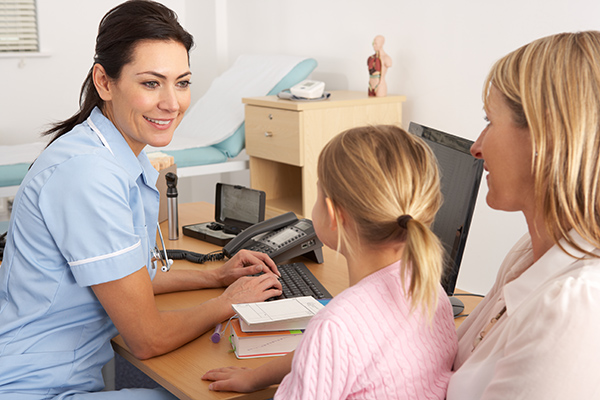 A doctor speaking to a child and parent